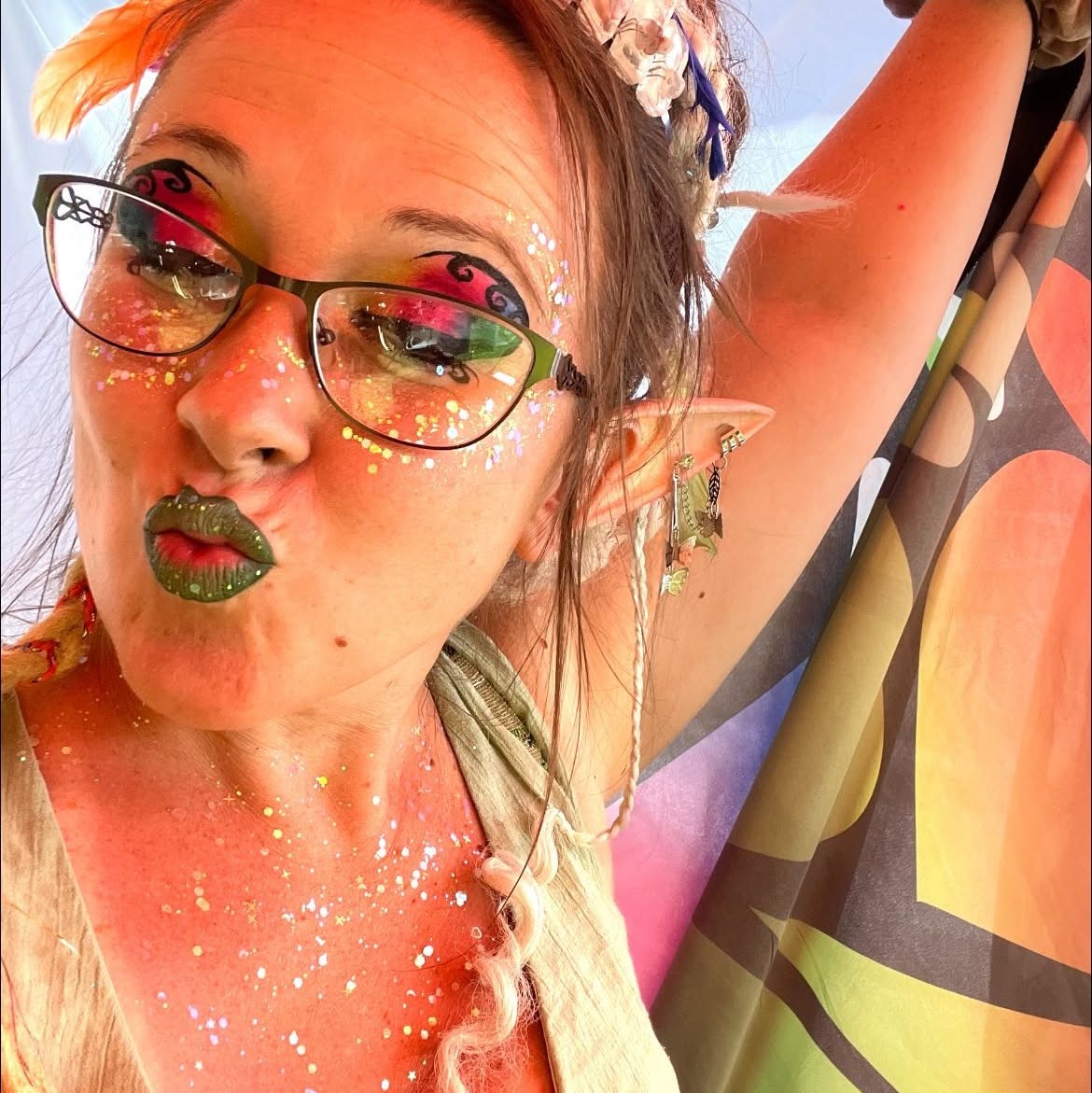 Fairy glitter makeup with olive lips, rhinestones and elf ears in warm golden light