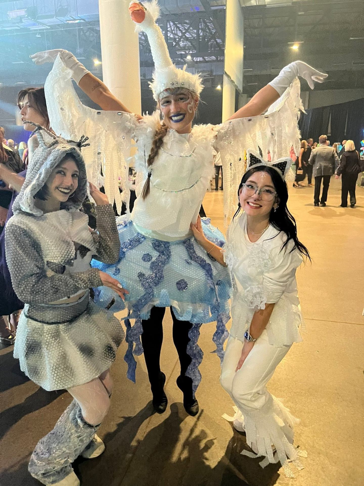 Full swan character transformation with feathered wings, headpiece and blue lipstick